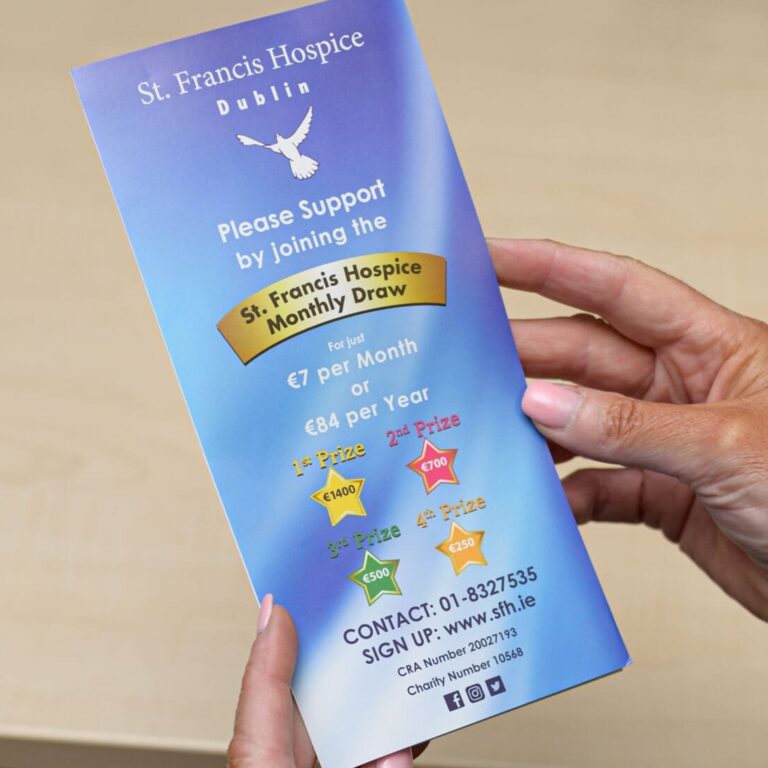 woman holds a leaflet with information about the hospice monthly draw